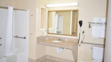 A bathroom with a bathtub, sink, mirror, towel rack, and toilet.