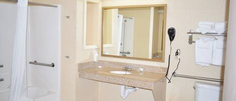 A bathroom with a bathtub, sink, mirror, towel rack, and toilet.