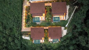 A modern, two-story house with a symmetrical layout, featuring a central garden area with a pathway, and two swimming pools, one on each side. - LALOON Luxury Suites - Adults Only, Santa Teresa Beach (Santa Teresa)