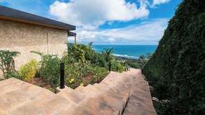 A modern building with a stone staircase leading to a balcony overlooking the ocean. - LALOON Luxury Suites - Adults Only, Santa Teresa Beach (Santa Teresa)