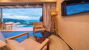 A modern room with a large window, a sofa, a table, and a lamp. - LALOON Luxury Suites - Adults Only, Santa Teresa Beach (Santa Teresa)