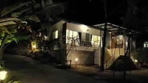 Ein modernes Haus mit einer überdachten Veranda und einer Treppe, die zum Eingang führt.