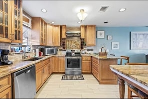 Enjoy cooking in this well-equipped kitchen with a central island, sink, oven, microwave, and dishwasher.