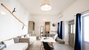 Een moderne hotelkamer met een bank, een eettafel en een kroonluchter.