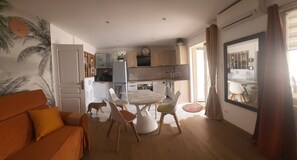 A compact living space with a dining area, kitchen, and a sofa.
