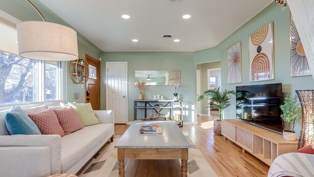 A modern living room with a sofa, coffee table, and TV. - Well-Appointed Family Summer Home - King Bed - Close to DEN & Anschutz (Aurora)