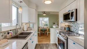 A modern kitchen with white cabinets, a stainless steel stove, and a microwave. - Well-Appointed Family Summer Home - King Bed - Close to DEN & Anschutz (Aurora)