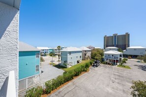 Un hotel a la costa amb edificis de diversos pisos, un aparcament i un cel serè.