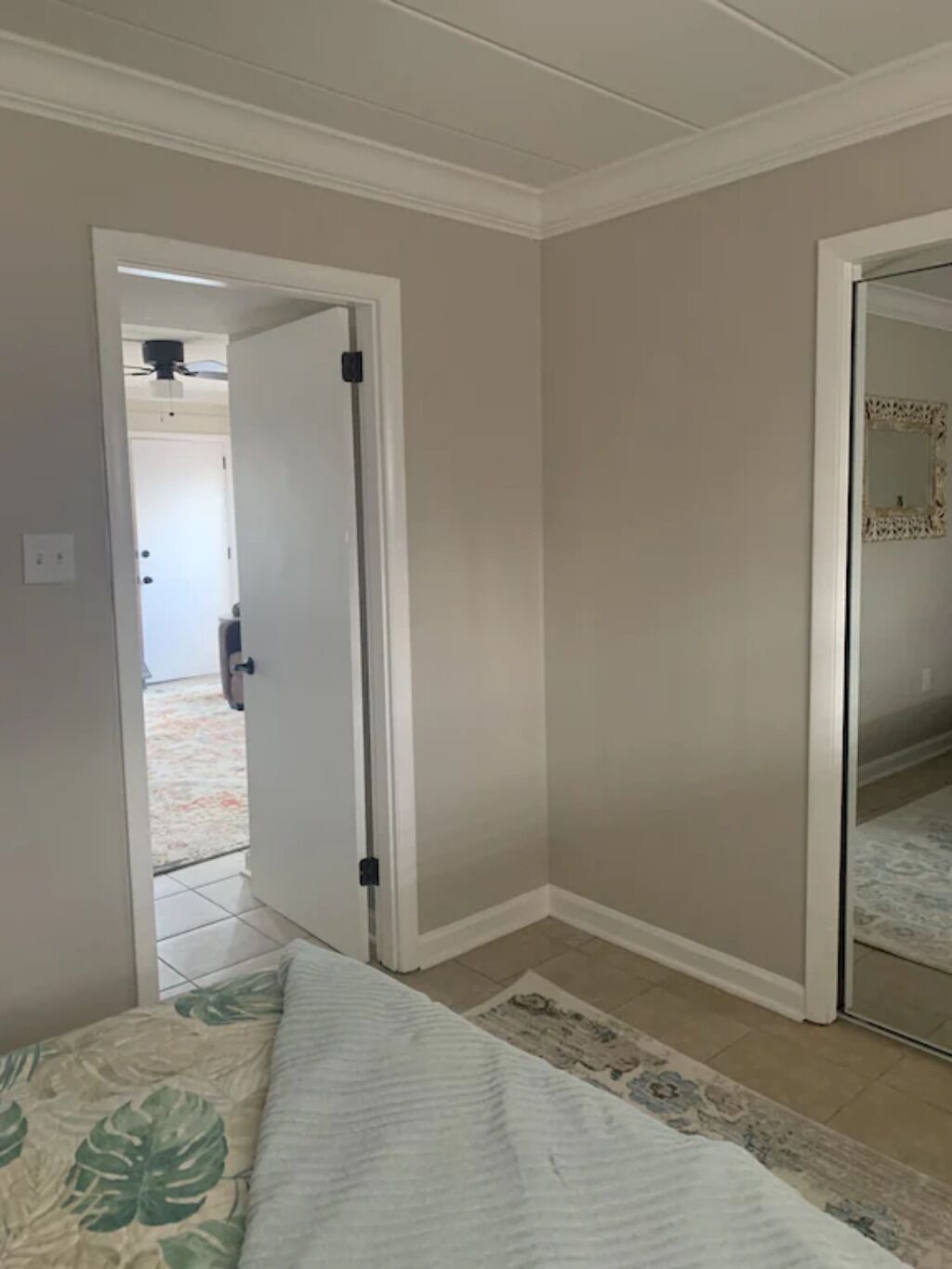 Una camera da letto con un letto, una porta che dà su un'altra stanza e un tappeto decorato.