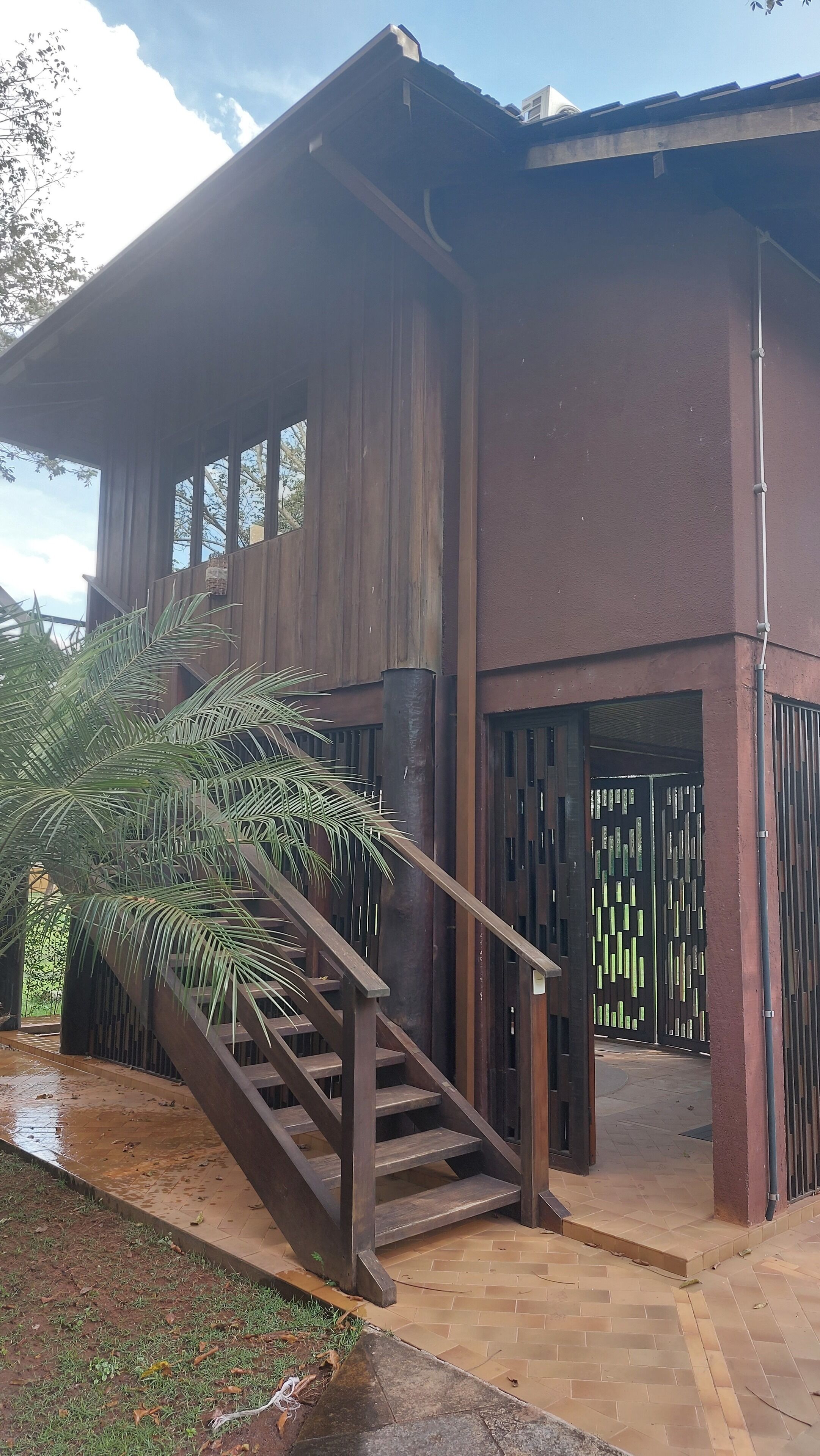 Un bâtiment moderne doté d’un escalier en bois menant à une entrée abritée.