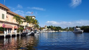 A waterfront area with buildings, a dock, and a yacht. - The Seaside Treasure *Sparkling Pool w Guesthouse* (Stuart)