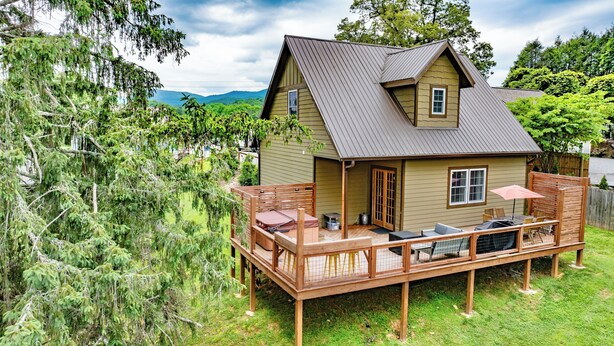 A two-story house with a deck, a small porch, and a covered outdoor seating area. - Newly built Luxury 3 bedroom Mountain Chalet in town - Hot tub and pet friendly! (Brevard)