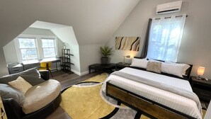 A modern bedroom with a loft-style ceiling, a large bed, a desk, and a seating area. - Newly built Luxury 3 bedroom Mountain Chalet in town - Hot tub and pet friendly! (Brevard)