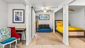 Una habitación compacta con cama, escritorio, silla y sofá.