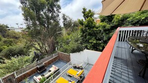 Terraza en la azotea con zona de estar, una piscina pequeña y abundante vegetación.