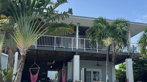 A building with a balcony, palm trees, and outdoor seating. - Special Rate Available August 2026 book now (Summerland Key)