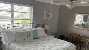 A bedroom with a bed, a desk, a chair, a ceiling fan, and a window with blinds. - Special Rate Available August 2026 book now (Summerland Key)