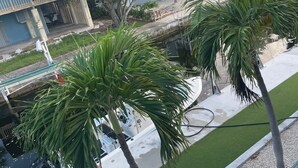 A residential area with palm trees, a swimming pool, and a building with a blue roof. - Special Rate Available August 2026 book now (Summerland Key)