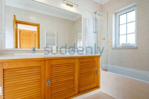 A bathroom with a wooden vanity, a large mirror, a shower, and a window. - Villa Vita, Bright and Sunny Villa Located at Praia D'el Rey (Amoreira)