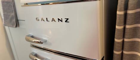 A white Galanz refrigerator with two doors and a metallic handle.
