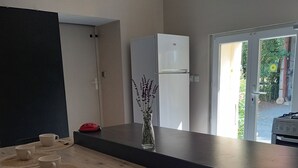 Eine moderne Küche mit einem Holztisch, gedeckt mit Schüsseln und Löffeln, einem Kühlschrank und einer Vase mit Blumen.