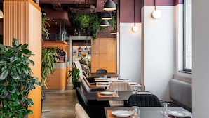 A restaurant with booths, tables, and a bar area. - Aparthotel Adagio Malta Central (Msida)