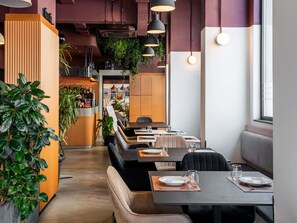 A restaurant with booths, tables, and a bar area.