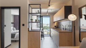 A modern kitchen with a built-in island, wooden cabinets, and a view to the outside. - Aparthotel Adagio Malta Central (Msida)