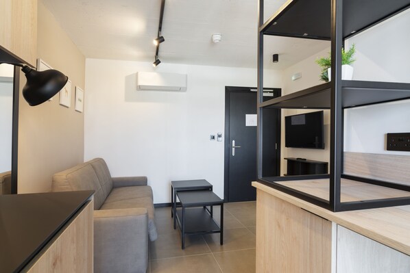 Departamento superior, 1 habitación | Área de sala de estar | Smart TV de 42 pulgadas con canales vía satélite, televisión y Netflix 