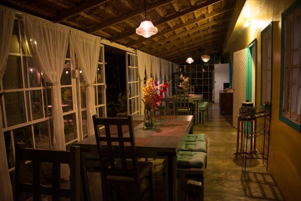 A cozy dining area with a wooden table, chairs, and a vase of flowers.