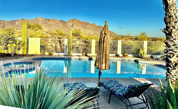 Relax by the serene pool surrounded by desert plants and majestic mountains.