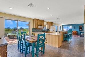Enjoy meals in the kitchen with a central island, appliances, and a dining area with a table and chairs.