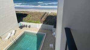 Zona de piscina con vista a la playa y al océano.