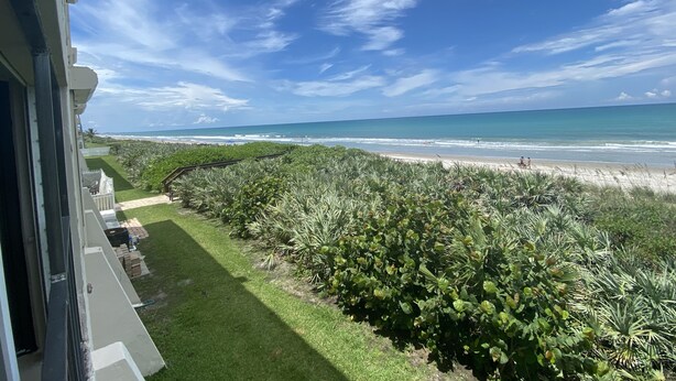 Un balcón con vista a una playa y el océano.