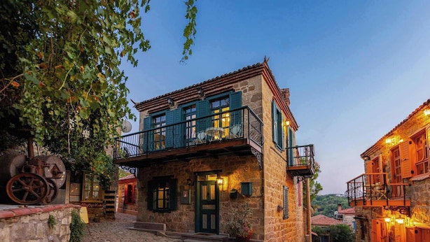 A stone building with a balcony, a cobblestone courtyard, and a rustic charm. - Orion Adatepe (Ayvacik)