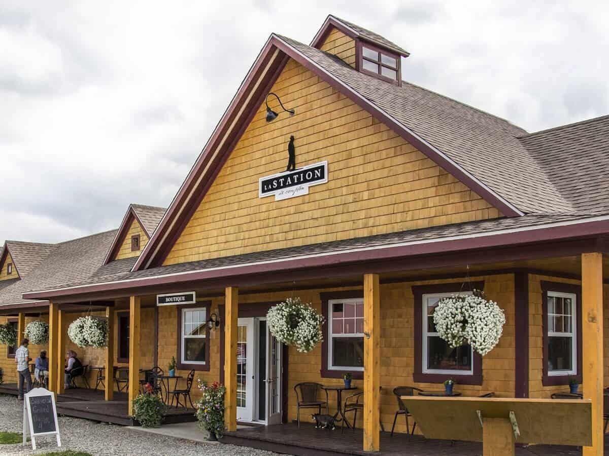 En träbyggnad med en skylt som visar texten ”SISTA STATIONEN” och en annan skylt med texten ”BUTIK”.