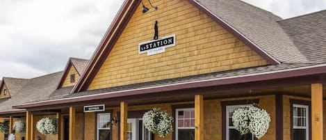 Un edificio de madera con un letrero que dice 'LAST STATION' y un letrero que indica 'BOUTIQUE'.