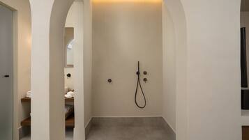 Une salle de bain moderne équipée d’une douche, d’un porte-serviettes et d’un miroir.