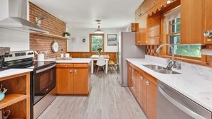 A modern kitchen with wooden cabinets, a central island, and a built-in oven. - Peaceful Mountain Retreat Near Appalachian Trail, Wineries, Breweries and More (Bluemont)