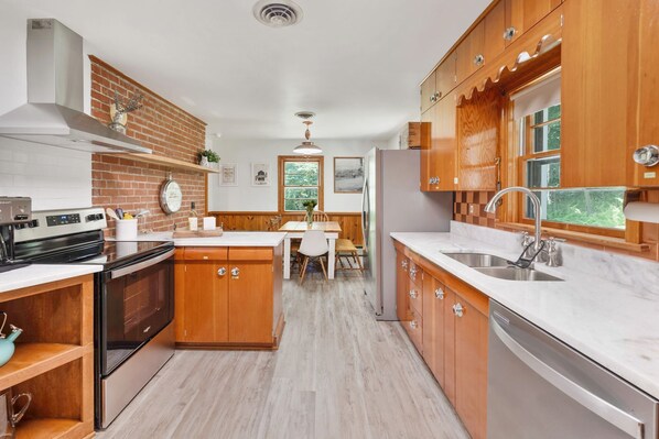 Una cocina moderna con armarios de madera, una isla central y un horno empotrado.