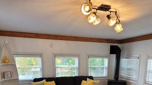 Una sala de estar acogedora con un sofá negro, una mesa de centro blanca y una chimenea.