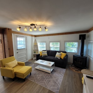 Una sala de estar acogedora con sofá, sillón y chimenea.