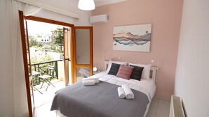 Una camera da letto con un letto, un quadro, un balcone con una sedia e un condizionatore d'aria.