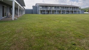 A building with a flat roof, multiple balconies, and a grassy courtyard.
