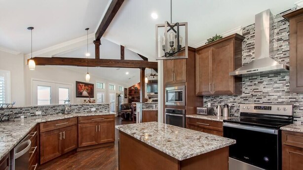A spacious kitchen with wooden cabinets, granite countertops, and stainless steel appliances. - Newly Renovated Private Ranch Get-A-Way (Pilot Point)