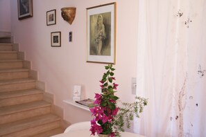 Stunning interior space with a staircase, artwork, and a potted plant.