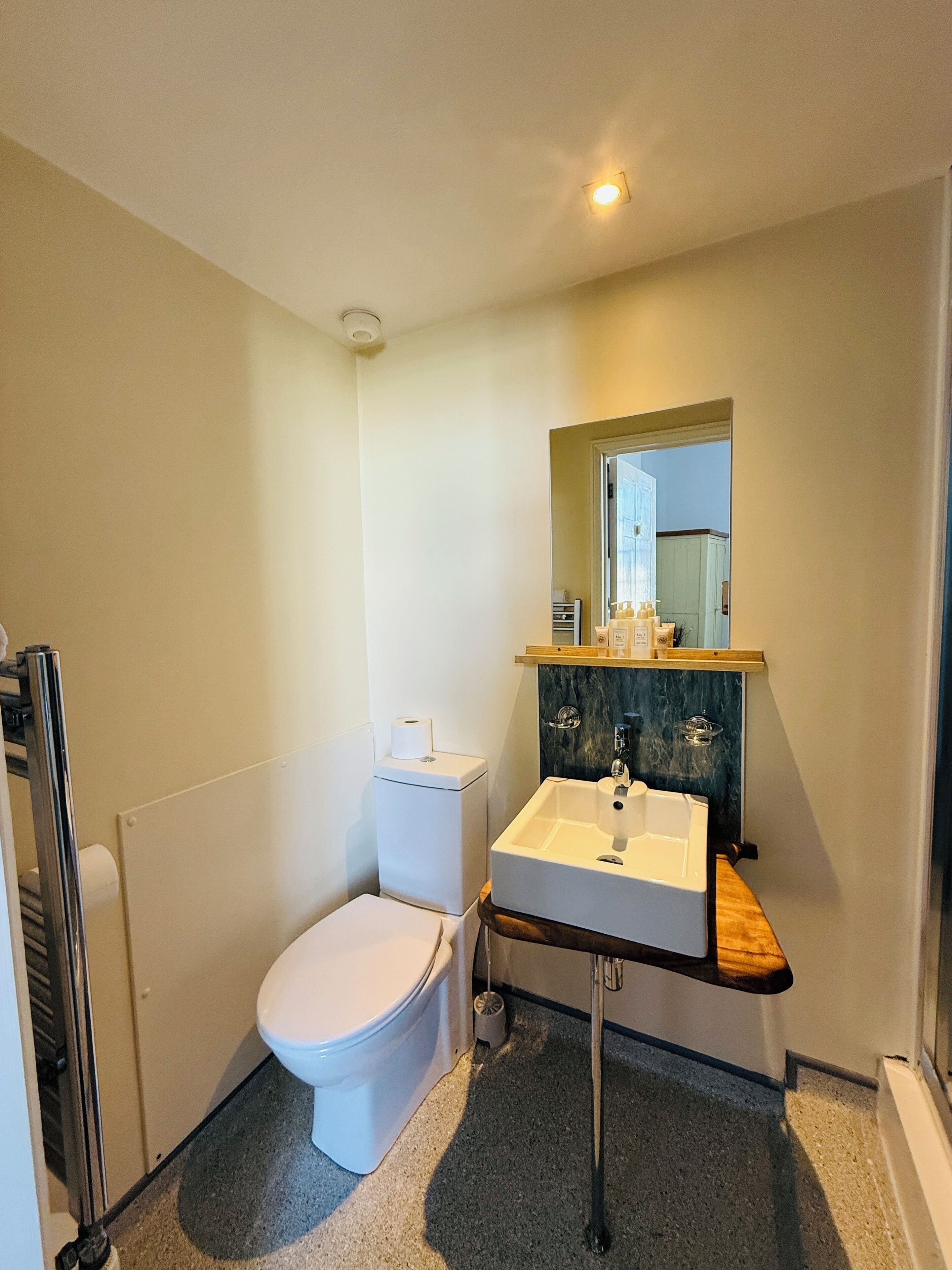 Une petite salle de bain avec des toilettes, un lavabo et un miroir.