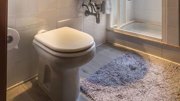 Une salle de bain moderne équipée de toilettes, d’un lavabo et d’une douche.