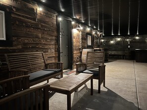 A rustic wooden interior with a dining area featuring wooden benches and a table. - Unique Underground Speakeasy With Hot Tub (Damascus)