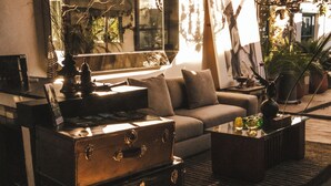 Un salon chaleureux avec un canapé, une table basse et une vieille valise.
